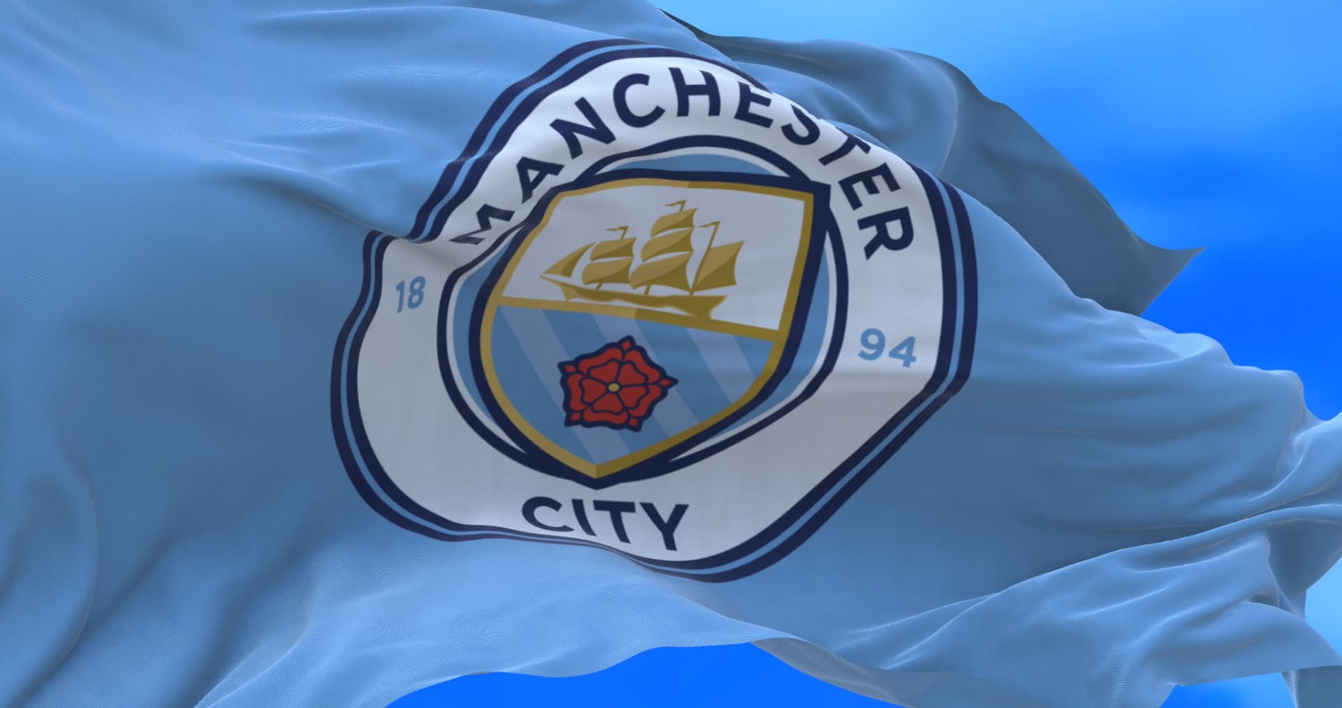 Manchester City flag flying against a clear blue sky
